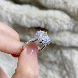 Macro shot of Radiant-cut sterling silver ring with halo setting and micro-pave band