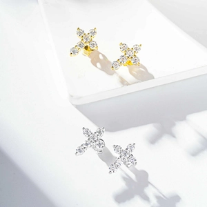Detailed view of silver and gold cross stud earrings featuring brilliant cut stones