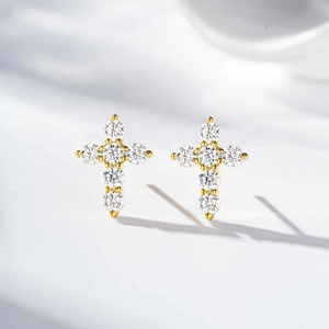 Close-up of gold-plated silver cross earrings set with round brilliant moissanite stones