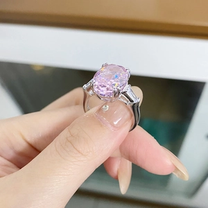 Detalle macro de un anillo con gran gema rosa ovalada y piedras de corte baguette