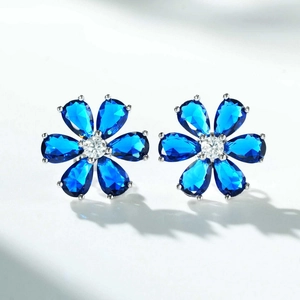 Detail of S925 silver flower stud earrings with blue pear-cut petals and center stone