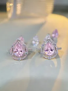 Macro shot of S925 sterling silver pear-cut pink gemstone rings with double halo setting
