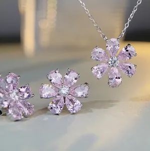 Macro shot of silver jewelry set with pink pear-cut crystals in floral design
