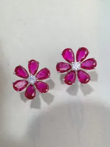 Close-up of S925 silver stud earrings with ruby-red petals and sparkling center stone