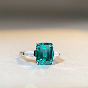 Macro shot of an emerald-cut green gemstone ring with baguette-cut side stones