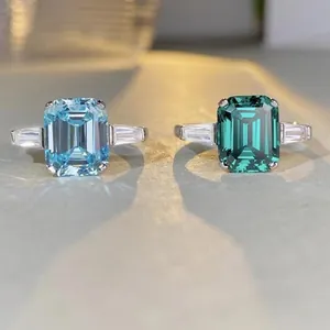 Macro shot of silver rings featuring emerald cut emerald and aquamarine zircon stones