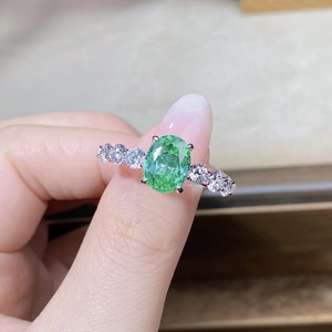 Gros plan d'une bague Paraiba ovale verte de 3 carats sur une monture classique en argent S925