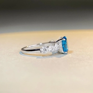 Macro side view of S925 sterling silver ring with oval blue gem and zircon details
