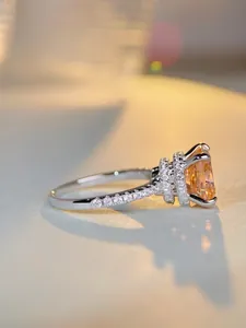 Detail view of champagne orange radiant cut gemstone ring with pavé diamond band
