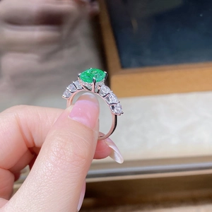 Vue macro d'une bague ovale en pierre verte de 3ct avec diamants sur argent S925