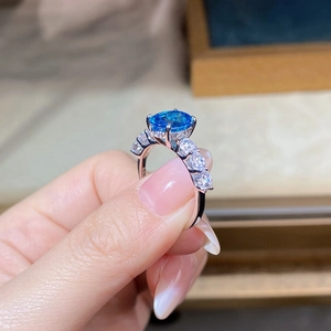 Macro shot of S925 silver ring featuring a large oval blue gemstone and white side stones