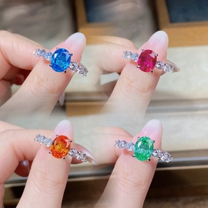 Detail of four colorful oval gemstones in silver rings with classic prong settings