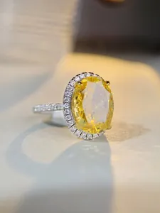 Vue macro d'une bague ovale en pierre jaune avec diamants halo sur argent S925