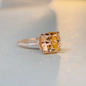 Luxurious cushion cut yellow gemstone ring with pavé diamonds in rose gold setting