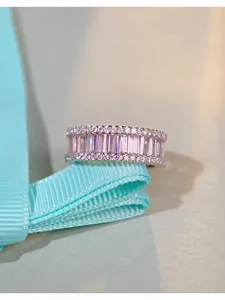 Vue macro d'une bague en argent S925 avec pierres roses et diamants sur ruban bleu satiné