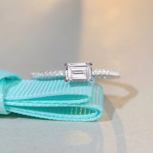 Elegant S925 sterling silver ring featuring emerald cut cubic zirconia on blue silk
