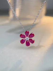 Détail du collier camélia avec rubis rouges taille poire et centre en diamant brillant