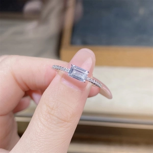 Macro shot of S925 silver ring featuring emerald cut center stone and side pavé diamonds