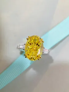 Macro detail of oval cut yellow diamond ring with trilliant side stones in S925 silver