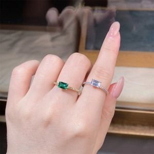 Close-up of stacked S925 silver rings with emerald and clear rectangle gemstones