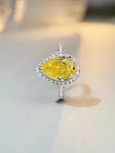 Macro shot of S925 silver ring featuring a pear-cut yellow gemstone in halo setting