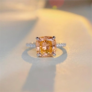 Vue macro d'une bague avec pierre jaune taille coussin et accents pavés sur monture argent