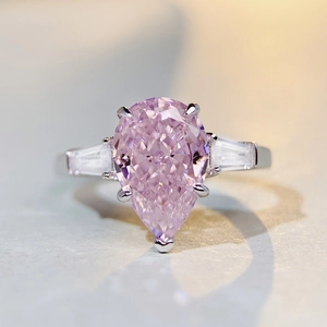Macro shot of s925 silver ring featuring a pear-cut pink gemstone and side accent stones