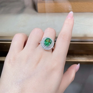 Dettaglio anello lussuoso in argento con grande pietra ovale verde e doppio alone di diamanti