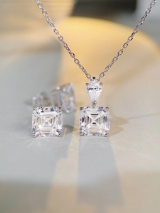 Detailed close-up of a square cut high carbon diamond pendant and matching stud earrings set