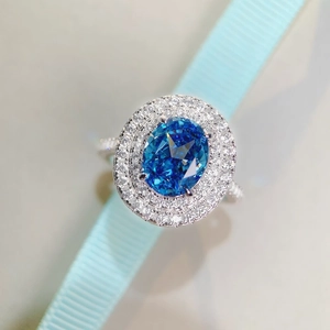 Luxury oval blue gemstone ring with double halo diamond setting and pavé band