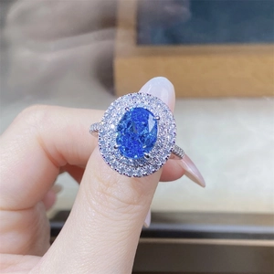 Close-up of luxury S925 silver ring featuring a large blue oval gemstone and halo diamonds