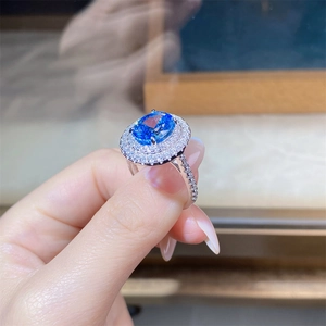 Close-up of a luxury oval sapphire ring with sparkling double halo diamond setting