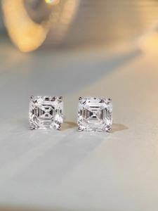 Macro detail of square-cut sparkling earrings with a classic four-prong silver setting