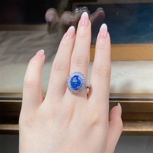 Detailed macro view of an oval blue gemstone ring with a sparkling double halo setting