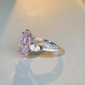 Detail view of marquise-cut pink gemstone ring with teardrop side stones in silver