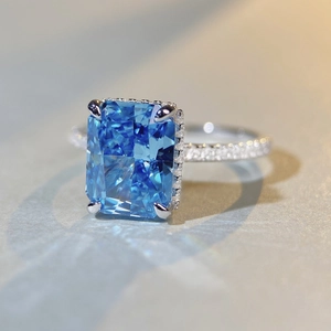 Macro shot of radiant cut blue gemstone ring with micro-paved diamonds on silver band