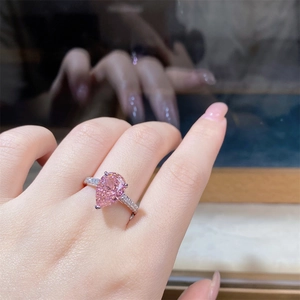 Close-up of pear-cut pink high-carbon diamond ring with micro-pave silver band