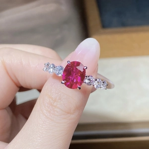 Close-up of S925 silver ring featuring an oval red ruby and sparkling side stones