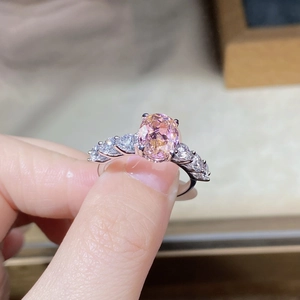 Macro detail of an oval pink gemstone ring with side diamonds in S925 silver setting