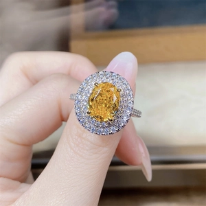 Macro shot of an oval yellow gemstone ring with double halo and diamond accents
