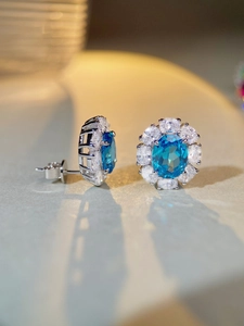 Macro shot of S925 sterling silver aquamarine earrings with oval halo and pavé setting