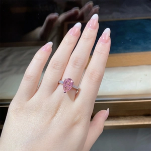 Macro shot of s925 silver ring featuring a pink pear-cut stone with accent diamonds