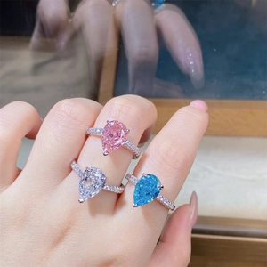 Macro detail of pear-cut pink and blue zircon rings with prong setting on finger