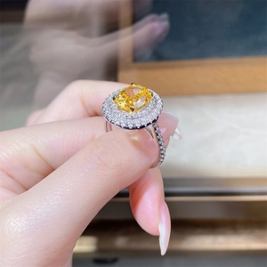 Detailed macro view of a luxury s925 silver ring featuring an oval yellow gemstone with halo diamonds