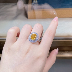 Macro shot of S925 sterling silver ring with oval yellow diamond in a halo setting