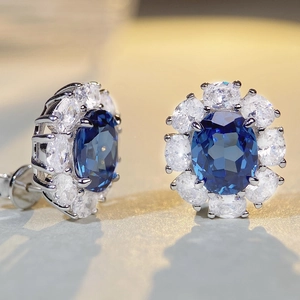 Deep blue oval gemstone flower earrings with sparkling white cluster diamonds in 925 silver