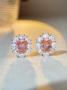 Gros plan de boucles d'oreilles en argent avec pierre rose ovale et halo de zircon