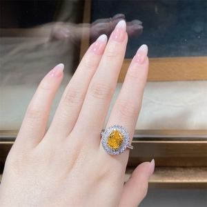 Detailed close-up of a halo set oval yellow gemstone ring in 925 sterling silver