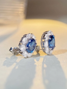 Detailed close-up of S925 sterling silver hallmark on blue halo stud earrings