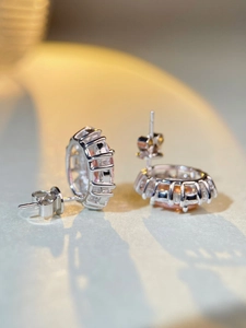 Détail macro de boucles d'oreilles halo en argent S925 avec saphir rose et zircons